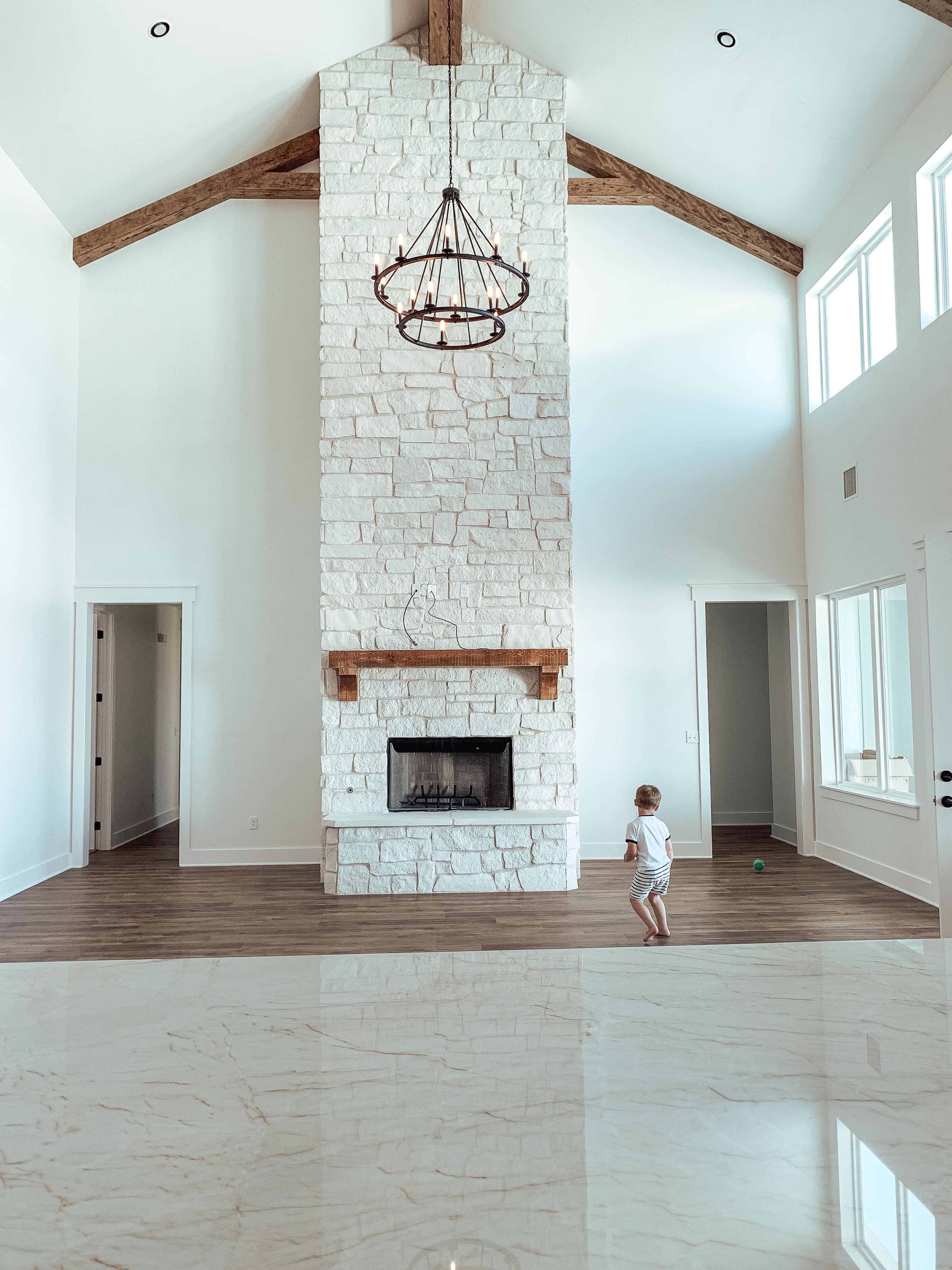 White stone with natural wood mantel to ceiling.jpg