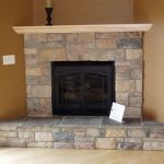 Corner stone fireplace with mantel, design installation by La Crosse Fireplace