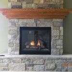 Rustic stone fireplace with mantel, installed by La Crosse Fireplace