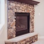 Corner fireplace made of stone installed by La Crosse Fireplace