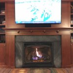 Slate fireplace surround with custom wood mantel and shelves
